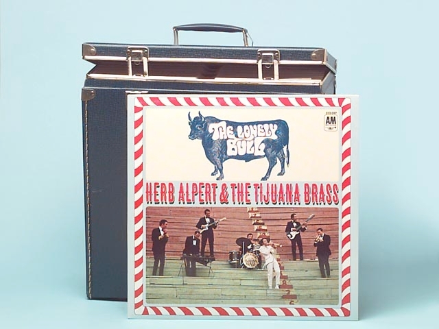 Boxen har beslag och lås i metall. Det finns två stycken nycklar till låsen som sitter fast i boxens handtag. I boxen finns det 20 st skivor. Det finns 7 st LP-skivor av AM Records, Hollywood, USA, med gruppen "Herp Albert's Tijuna Brass" från 60-talet. Det finns 11 st skivor från Reader's Digest, England. De har ett samlingsnamn "Magical words of melody" men det är olika musik på varje skiva t.ex Strauss, Grieg, Gershwin. Sign-märk På den marinblåa skivboxen är det inristat dels texten "Alstermo bruk", dels en vapensköld med en pegasus som bild.