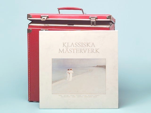 Boxen har metallbeslag och lås. Till de två låsen finns det två nycklar, som sitter fast på boxens handtag. I boxen boxen finns det 12 st LP-skivor av blandat slag. Det finns bl.a. Louis mästerverk", Göran Söllscher, Alfvén: Symfoni nr.3 E-dur, Belafonte, körmusik från Växjö Domkyrka, Martin Lindström med Stockholms KFUM kör, West Side Story. Det finns tre stycken stenkakor (78-varvare). Det är två stenkakor från Oden Record, "Jag älskar Norden" och "Aftonhymn". En skiva av Decca Rec. Sign-märk: På den röda boxen är det inristat Alstermo bruk och en sköld av något slag. I skölden finns en pegasus.