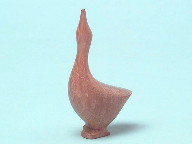 En träfigur som föreställer en gås. Utformningen är enkel och träet har en slät yta. Träets ådringar bildar ett naturligt mönster.