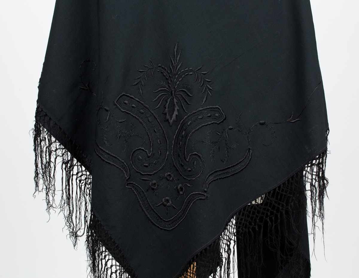 Rektangulært. Brodert i hvert hjørne. Lange frynser. Brukt til begravelser.
Sydd av Olea Bolette Ambjørnrud, f 1862, mor til giver,  gift med Hans Svendsen. 
Giver Olga Ambjørnrud. Se personpost biografi.