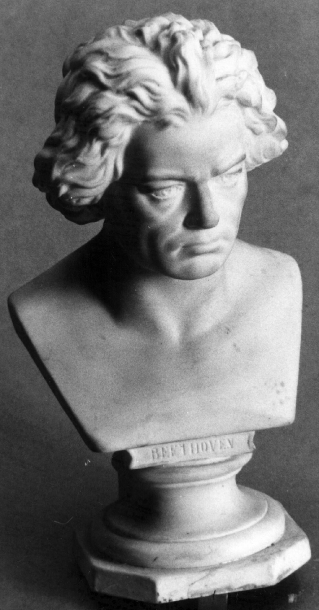 Byste av Beethoven i bisque. Bysten er montert på en rund sokkel, som går over i 8-kantet plate.