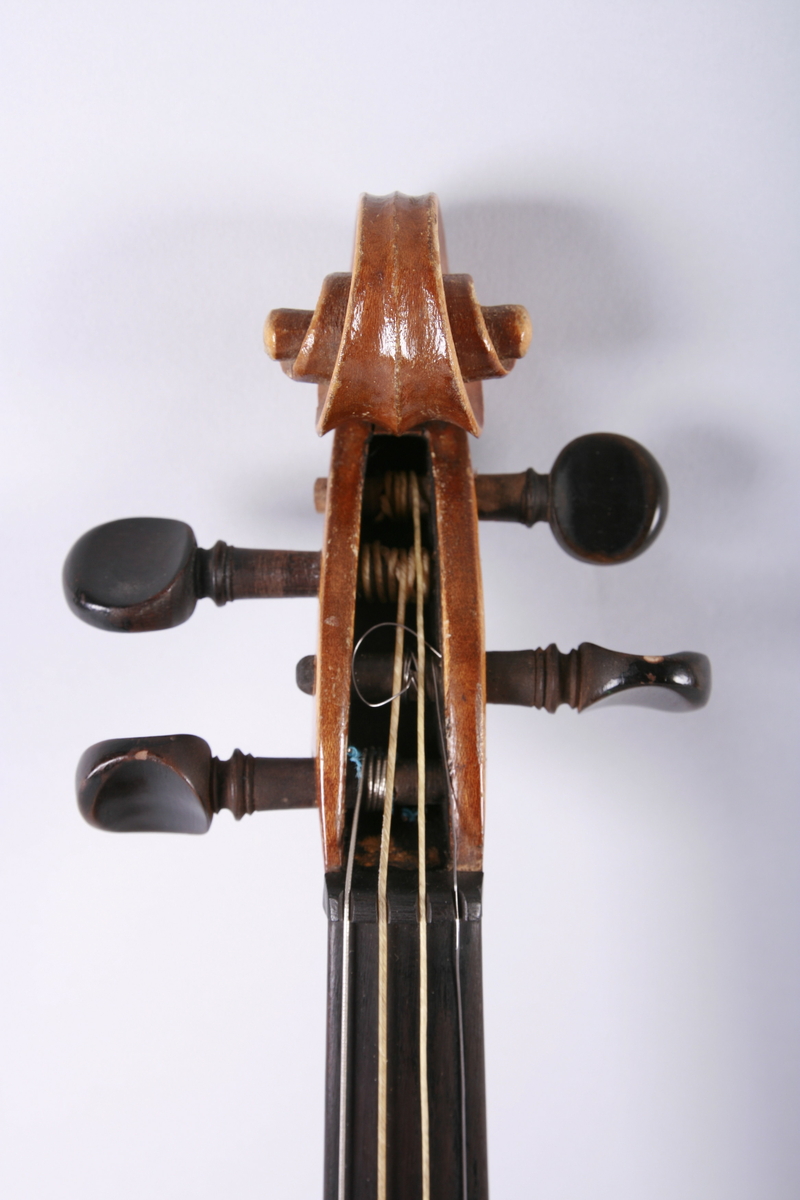 Strengeinstrument i mindre størrelse, 1/4 format(?). Lokk av gran, bunn og sarg ahorn. Lys lakkert. Gripebrett, strengeholder og endeknapp ibenholt. Sortmalte skruer. Mangler hjørneklosser.