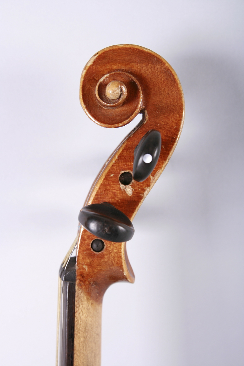 Strengeinstrument i mindre størrelse, 1/4 format(?). Lokk av gran, bunn og sarg ahorn. Lys lakkert. Gripebrett, strengeholder og endeknapp ibenholt. Sortmalte skruer. Mangler hjørneklosser.