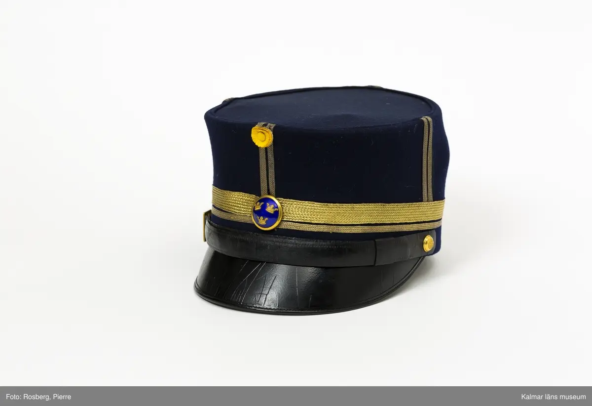 KLM 19048:4:1. Mössa. Käppi. För major. Mössa av mörkblått kläde. Rak i sidorna. Platt kulle. Svart skärm. Fyra st. dubbla stolpar av guldgalon på kullens sidor. Liten kokard av gult siden mitt fram med två plisserade ringar. Blå emaljerad mössknapp med tre kronor, under kokarden. Mössrem av svart skinn med spänne av gulmetall ovanför skärmen, fästs i mössan med liten kulknapp av gulmetall. Två rader guldgalon nära mössans nederkant, en smal och en bred. Svettrem av brunt skinn. Kullen fodrad med blankt satinvävt svart tyg. Tryckt text i guld i kullen: MILITÄR EKIPERINGS A.B. STOCKHOLM M.E.A. samt ägarinitialer  PH. V. K.
Mössan förvarades på kullen i hattask KLM 19048:4:2.