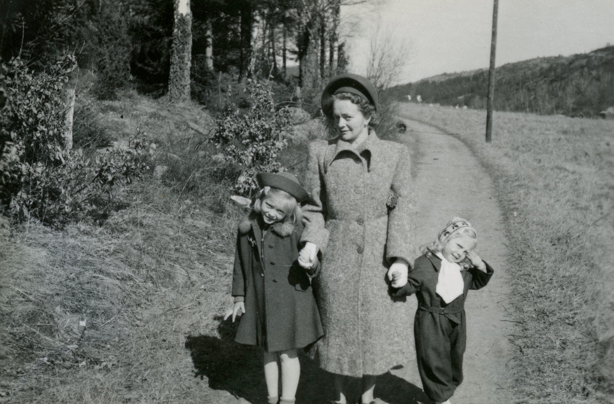 Rosa Pettersson (1912 - 1994) och döttrarna Eva (född 1944, gift Kempe) samt Karin (född 1947, gift Hansson) promenerar på "Hernkvistens väg" år 1950. Det var en väg som gick från Kållereds centrum (Gamla Riksvägen) över Kärret (innan motorvägen byggdes) till Torrekulla. Vägen kallades "Hernkvistens väg" efter en familj som ägde en gård vid nuvarande Märgelvägen.