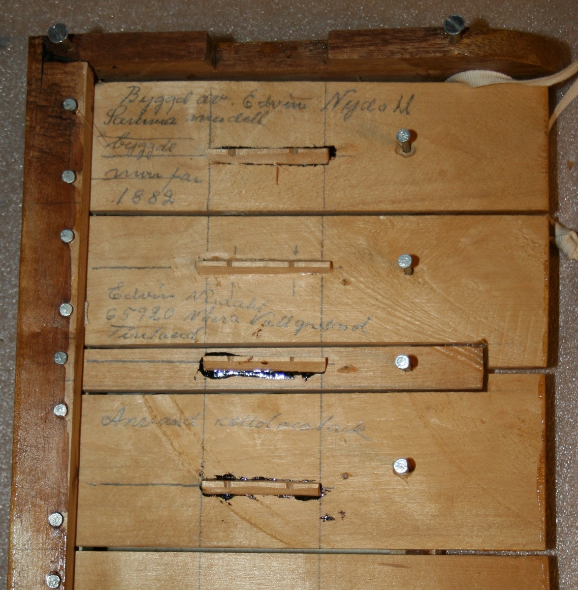 Salmodikon, med tilhørende klaviatur. Spilles med bue [mangler].

Kasse av nåletre. Hel bunn, flat lokk, et stykke på hver side. Lakkert. En malt/innbrent(?) dekorlinje.  To lydhull. Lydpinne festet med snor, det vil si justerbar. To strenger av nylon. Strengeholder av løvtre. Endeknapp i plast. To grove stemmeskruer (løvtre). Flat grov stol.

Tastatur
Mekanikkasse av nåletre. Hoder på spiker i de fire hjørner passer til urgröpningar på kassens lokk.
31 taster, c-g’’, kromatisk, unntatt ”c#” som er en blindetast. Undertaster av bjørk(?); overtaster ditto, med kub-formet lakkerte halvtoner. Styrstifter av spik(!). Hengslinger av resorband festet på oversiden av tasten ved en skrue og skålformet plate, samt i bakre vegg.
Tangenter (sammenlikne med et klavikord!) av løvtre, med urtag for strengen. Posisjoner for tangenter på underside av taster markert med blyantstreker. Skala ikke oppmålt (men se bilder med linjal).