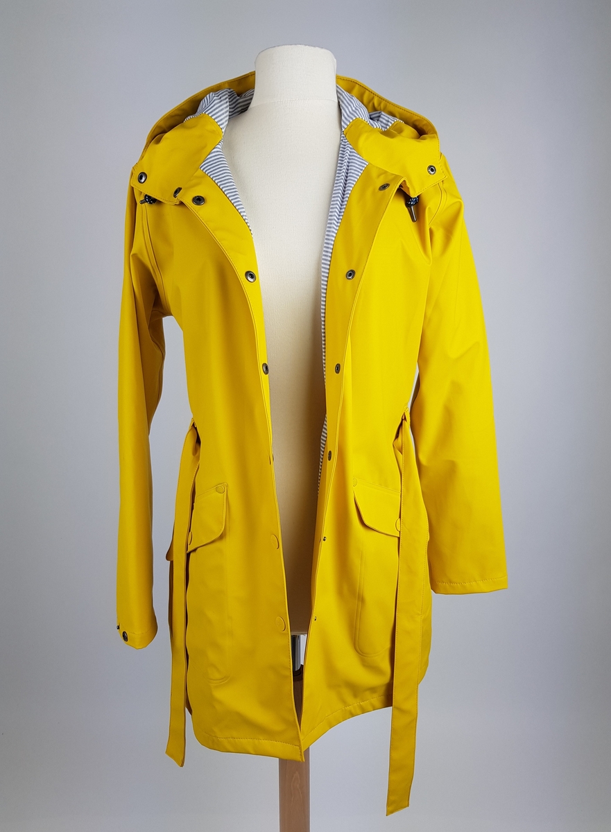 Gul, halvlang, myk regnjakke med hette, preget med HH på alle knappene midt foran. Midt bak et bærestykke, som er sveiset fast på to plasser. Også sveiset midt bak, og utstyrt med en motfold rett nedenfor livet. Løst, sveiset belte og sydde hemper. Skuldersømmen er flyttet litt foran. Gummiert, gult HH merke er innsydd. Lommer med klaff. Trykkknapp midt på klaffen, nagler på begge sider av klaffen. Snor i hetten, med stoppere. Lukkes midt foran med gule trykknapper preget med HH. Trykknapp-regulering nederst på erme. Jakken er fôret med smalstripet hvit og lys grått stoff. Ermene er fôret med svart fôr, Nederst på ermet er det sydd på 5,5 cm fôr lik jakken. Jakkens sømmer er sveiset.