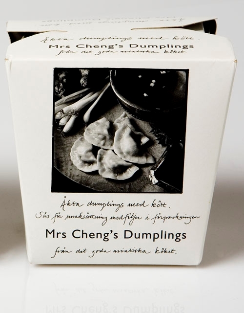 Vit fyrkantig förpackning med svart text och svart/vitt foto av en äldre person som sitter på en stol. Under fotot texten. På baksidan ett svart/vitt foto av ett bord med dumplings, gryta
att koka dem i och vårlök. Samma text som på framsidan.

Äkta dumplings med kött.
Sås för smaksättning medföljer i förpackningen.
Mrs Cheng´ s Dumplings
från det goda asiatiska köket.