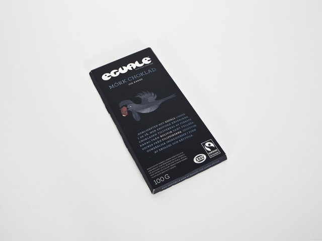 Design- Förpackningsdesign. Förpackning för Sackéus 70 %  mörka choklad 100 G.
Diplom

Förpackningen är svart med grå text och motiv på en fågel som flyger med en kakaoböna i näbben. Runt chokladen har det varit ett foliepapper i guld.

Fyrfärgstryck.

Rättvisemärkta produkter har länge dragits med en foträt hemmasnickrad stämpel. Varje förpackning berättar en egen liten historia-om produkten, fåglen och deras exotiska ursprung. Som umbrella bird från Bolivia, med en kakaoböna i näbben. Eller en Velvet-fronted Nuthatch från Kina, med ett hallon i näbben. Sobert svart håller ihop sortimentet i hyllan och adderar en premiumkänsla. Sortimentet består av 28 produkter.

Ecuale Fair
Trade Since 1976

MörkchokladEcuale Fair Trade Since 1976

Mörk Choklad
70% Kakao

Hemligheten med Eguale ligger i de få, men exotiska råvarorna. Chokladen tillverkas av finaste kakao från Bolivia samt fullrörsocker från Filippinerna. Dessutom oumbärliga ingridienser i form av ekologi och rättvisa.

Amazonian Umbrellabird från Bolivia har något som påminer om ett paraply på huvudet (och låter som en ko). Skygg men siktas då och då i närheten av kakaoplantager med ett gott rykte.

(Baksida)
Eguale (jämnlikhet) var först i Sverige med att erbjuda ett sortiment av KRAV- och Rättevisemärkt choklad. Eguale Mörk 70% har en fruktig arom och låg bitterhet. Och är en ren naturprodukt utan konstgjorda tillsatser. Den utsökta smaken har sitt ursprung i kakaon från främst  El Ceibo-Kooperativet på Filippinerna, båda ekologiskt odlade. Småproducenterna erbjuds förbättrade arbets och levnadsvillkor samt en premie förlokala utvecklingsprojekt.