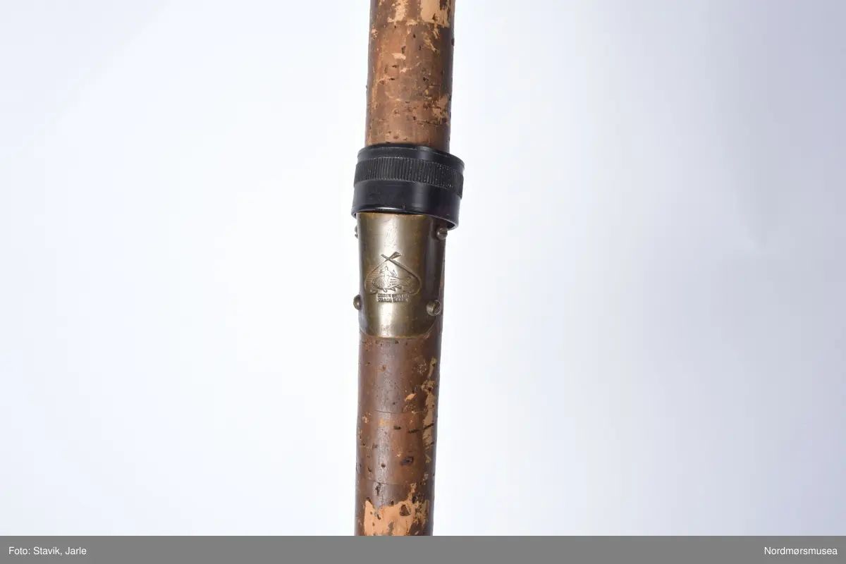 Todelt greenheart med nytt futeral. Håndtak av kork. Agat i øvre og nedre ring. Påsatt nye rettstilte moderne ringer. Stangen har vært ombygd på et tidspunkt. Treknopp på enden. Ogden smiths merke med to motstående fiskekroker på falen sammen med produsentens navn. Sammensetting vha. glatte messingholker.
