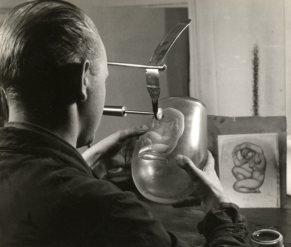 Orrefors glasbruk.
Gravör Ernst Åberg graverar ett motiv på en vas.