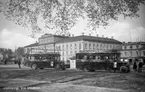 Hamnplan var busstation för linjen Jönköping-Taberg. Två bussar, tillverkade 1927-1928 står vid hållplatsen. Andra sidan kanalen syns Stora hotellet till vänster och Lilla hotellet till höger.