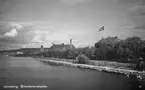 Strandpromenaden utmed Vätterstranden anlades på 1850-talet, redan innan järnvägen drogs här. Tegelfastigheten Norra Strandgatan 4, där flaggan är hissad, byggdes 1918. Till vänster om den ligger Stora hotellets trädgård, där man hade servering och olika evenemang. År 1928 fick trädgården lämna plats åt nybyggnader.