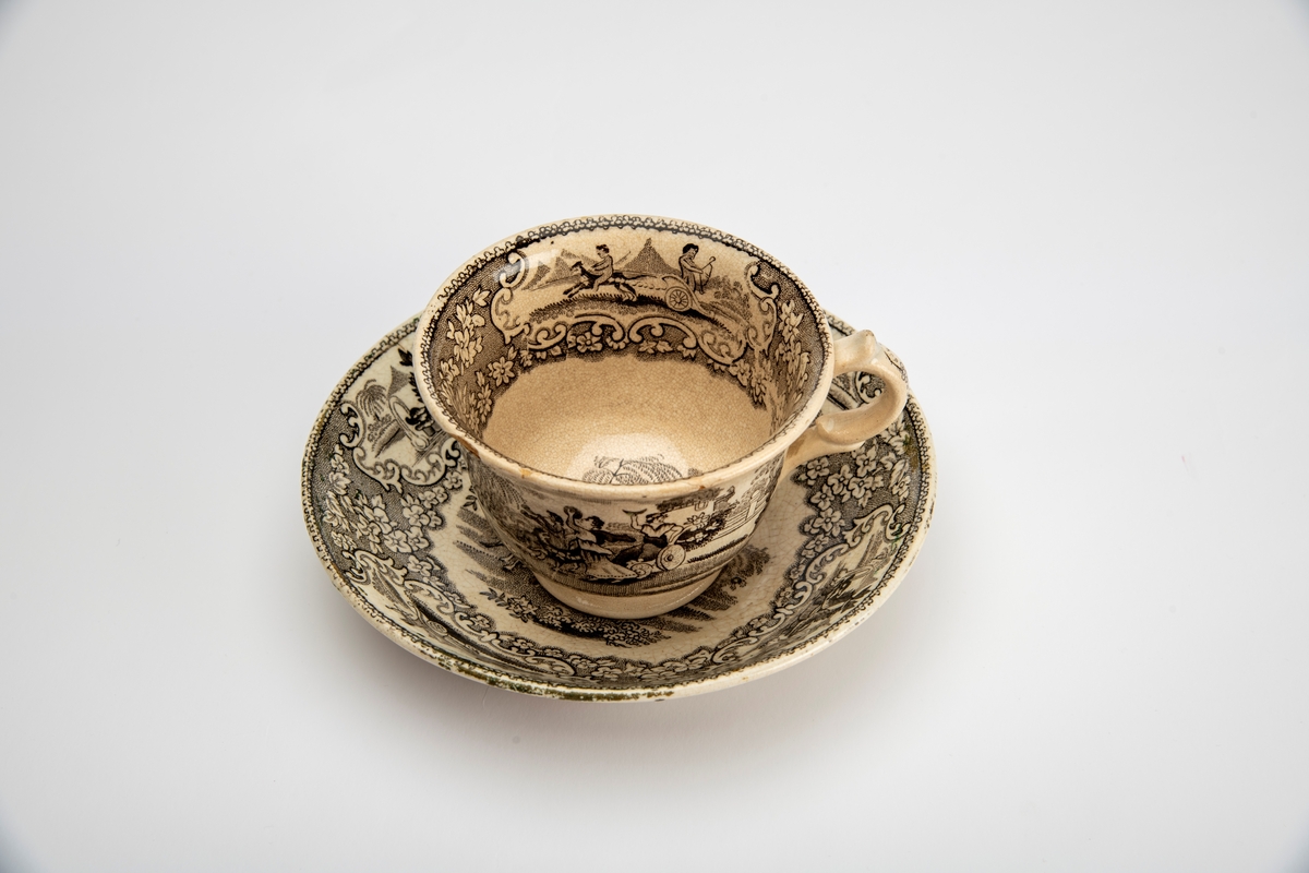 A: Kopp. Sidene utsvunget mot munningen, innsvunget mot fotring, buet,  fliket hank. Trykt dekor i brunsort:  Opptog som kjører gjennom en park, gjentatt på begge sider av koppen,:  innv. meget bred bord m. blomster, samt felt med bueskytter i 2-hjuls stridsvogn, trukket av hund med rytter. Et annet felt med springvann, dannet avto delfiner, pseudorokokko innramming, i bunnen parklandskap med urne og busk, samt svaner som seiler i en damm.  

B: Skål. Lite, flatt speil, buede sider; sidene dekket av blomsterbord m. fire felter: To med delfinspringvann  To med bueskytter i stridsvogn; i speilet det kvinnelige opptog i parken.  Stemplet under bunnen: " Triumphal Car"  under due med utspilte vinger og glorie, dessuten:  J Jamieson & Co.