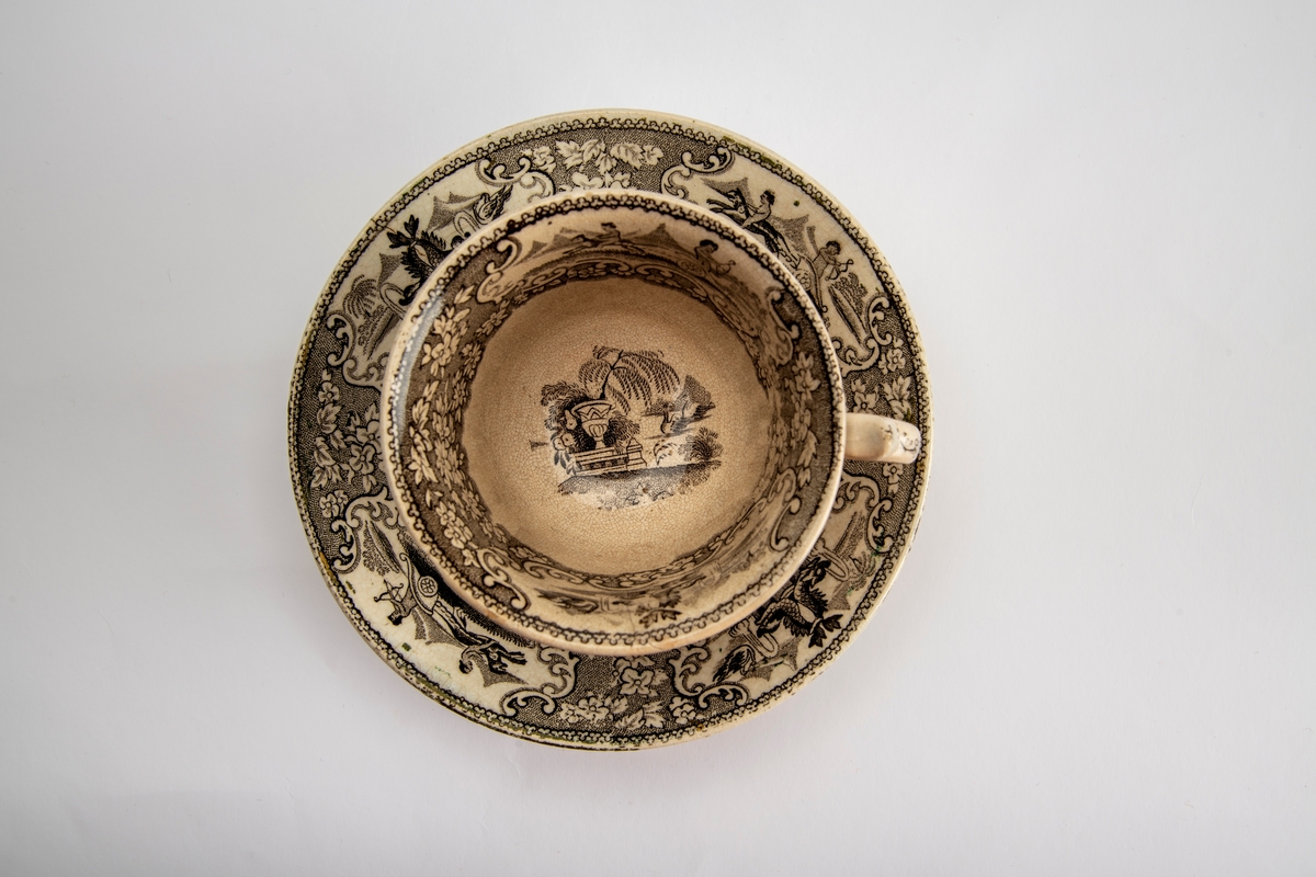 A: Kopp. Sidene utsvunget mot munningen, innsvunget mot fotring, buet,  fliket hank. Trykt dekor i brunsort:  Opptog som kjører gjennom en park, gjentatt på begge sider av koppen,:  innv. meget bred bord m. blomster, samt felt med bueskytter i 2-hjuls stridsvogn, trukket av hund med rytter. Et annet felt med springvann, dannet avto delfiner, pseudorokokko innramming, i bunnen parklandskap med urne og busk, samt svaner som seiler i en damm.  

B: Skål. Lite, flatt speil, buede sider; sidene dekket av blomsterbord m. fire felter: To med delfinspringvann  To med bueskytter i stridsvogn; i speilet det kvinnelige opptog i parken.  Stemplet under bunnen: " Triumphal Car"  under due med utspilte vinger og glorie, dessuten:  J Jamieson & Co.