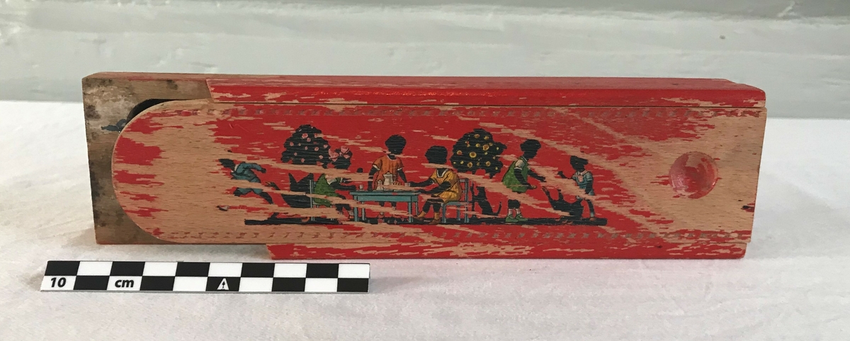 På lokket er det avbildet seks barn som leker: Fra høyre til venstre, en gutt som løper, tre barn som leker teselskap, samt to barn som leker med en hund. 