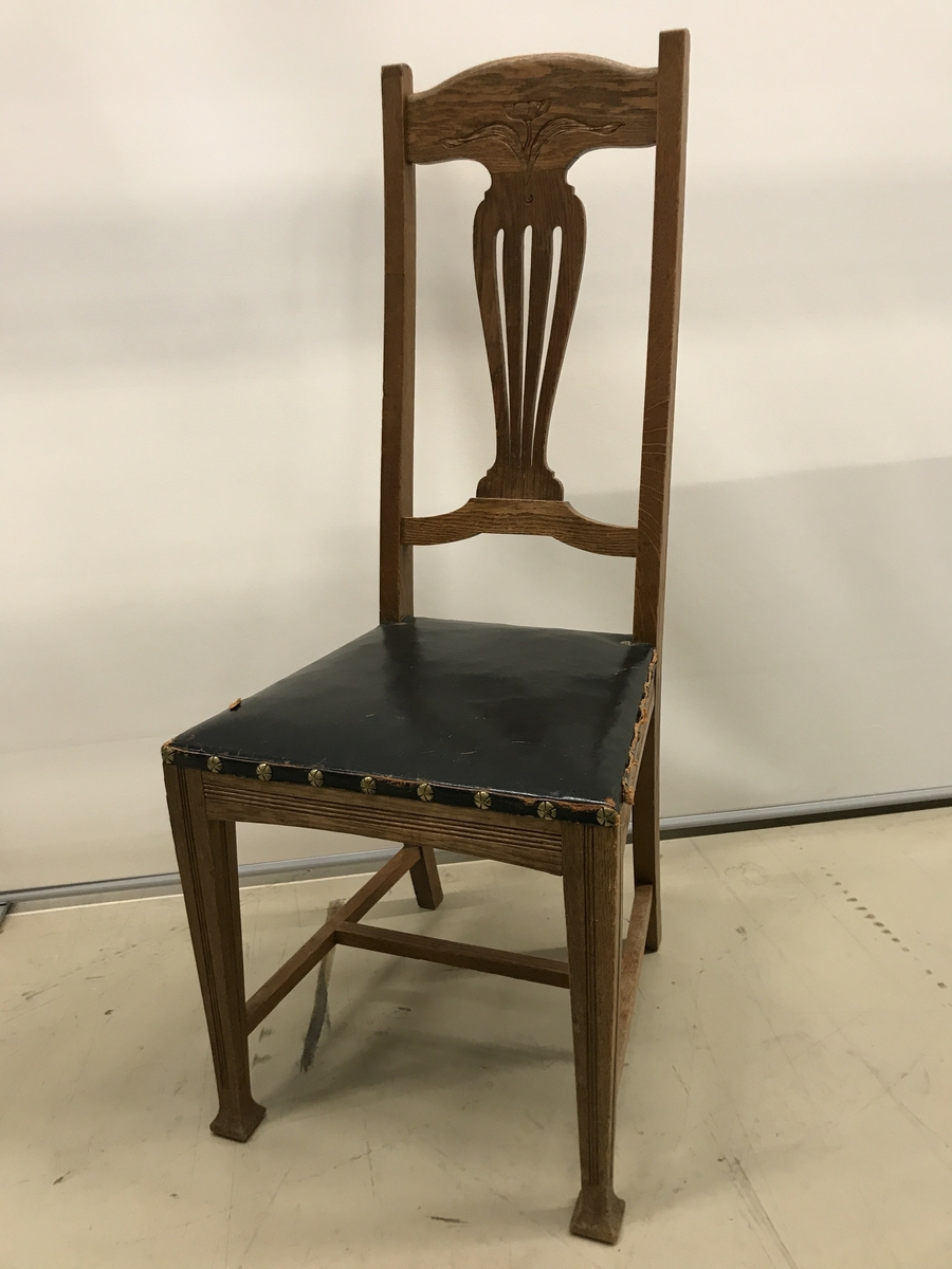 Sex ekstolar med genombruten ryggbricka som dekorerats med stiliserad blomma. Sits av svart läder.