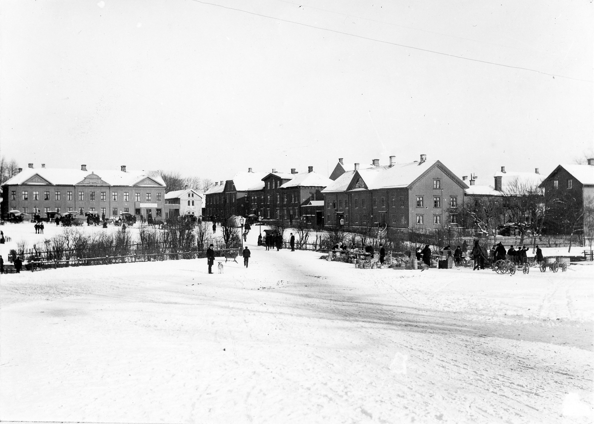 Stora torget fotograferat från Lilla torget. På bilden syns människor och djur i rörelse samt viss handelsverksamhet.