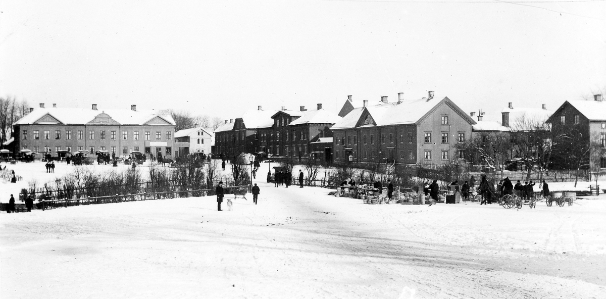 Stora torget fotograferat från Lilla torget. På bilden syns människor och djur i rörelse samt viss handelsverksamhet.