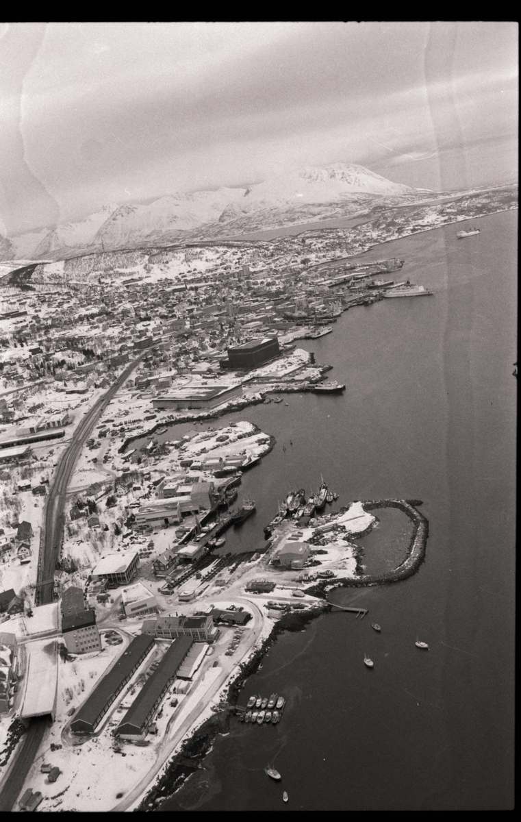 Flyfoto, tatt fra Harstadbotn og utover mot Harstad sentrum. Yrkesskolen og Mathiassenverkstedet i forgrunnen, "Brunosten" midt i bildet.