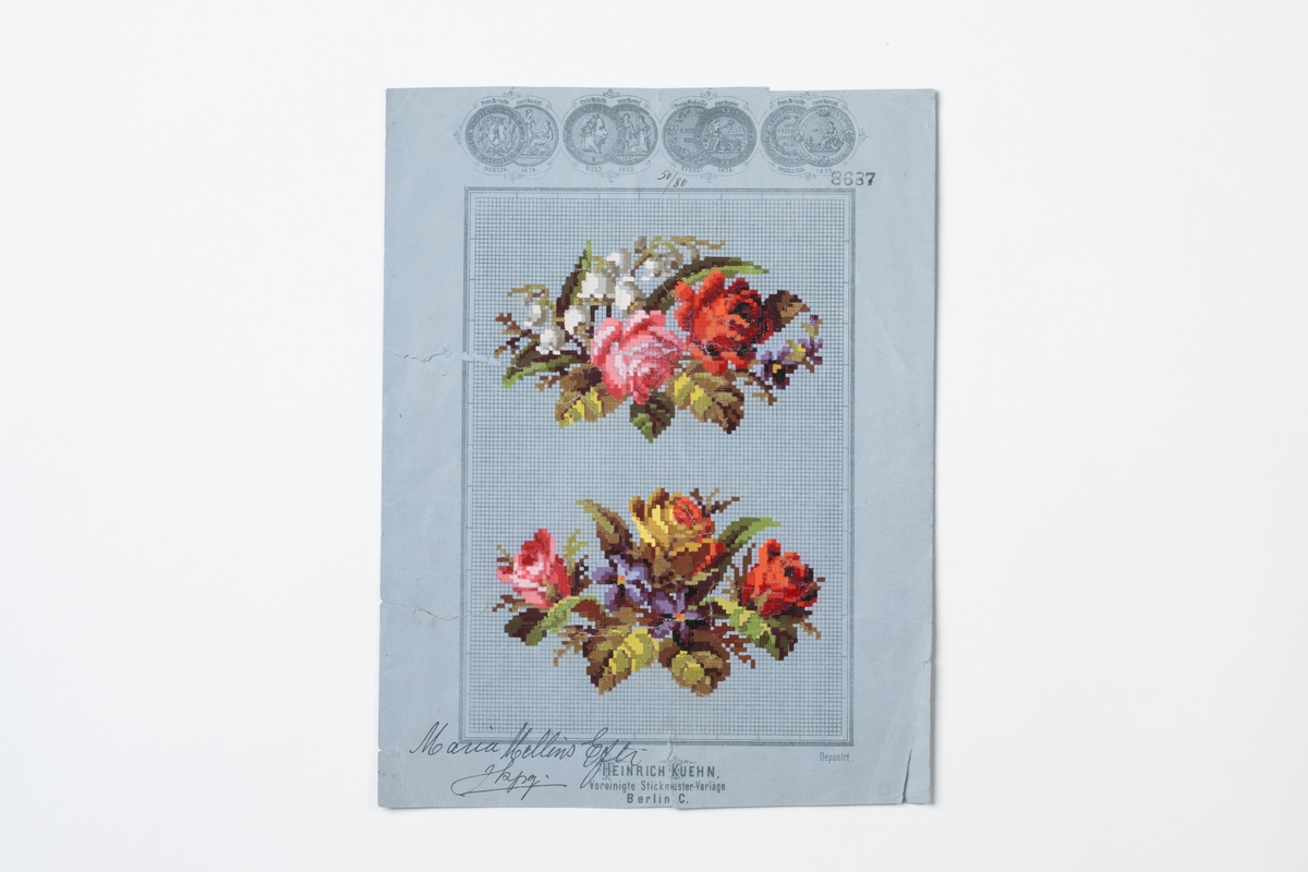 Broderimönster på pappersark. Mönstret är tryckt på smårutat blått pappersark, och består av två olika blommönster med röda, rosa och blåa blommor och gröna blad. Tryckt text: ”8687",  "HENRICH KUEHN, Vereinigte Stickmuster-Verläge BERLIN C." och "Depornit”. På arket är även handskrivet med tusch: ”Maria Mellins Eftr JKPG." och "50/80”. Arkets kanter är klippta och har revor. Två revor är förstärkta med påklistrade pappersetiketter på baksidan av arket.
