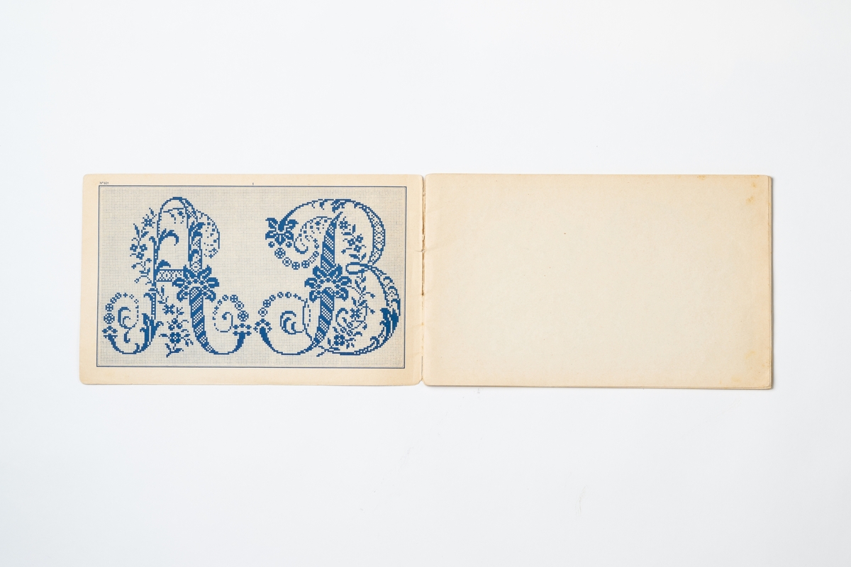 Broderimönster i häfte med omslag av orange papper. Häftet innehåller 16 mönsterblad med tryckta bokstäver/monogram på smårutat papper. På omslagets framsida tryckt text: ”G. LEFÈVRE & CABIN FILS successeurs. Dessins de Broderies 74. Boul.d Sébastopol PARIS Album No. 601”. Tryckt text på baksidan av omslaget.