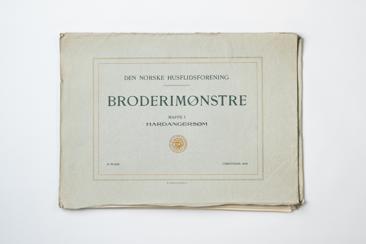 Mapp av papper med mönster på hardangersöm (vitbroderi). Häftet innehåller 10 blad i form av tryckta fotografier i svart-vitt. På mappens framsida tryckt text: ”DEN NORSKE HUSFLIDSFORENING BRODERIMØNSTRE MAPPE 1 HARDANGERSØM CHRISTIANIA 1906”. Mappens pris 3.00 kr och enkelt blad 0,35 kr. Tryck: W.C. Fabritius & Sønner A/S.