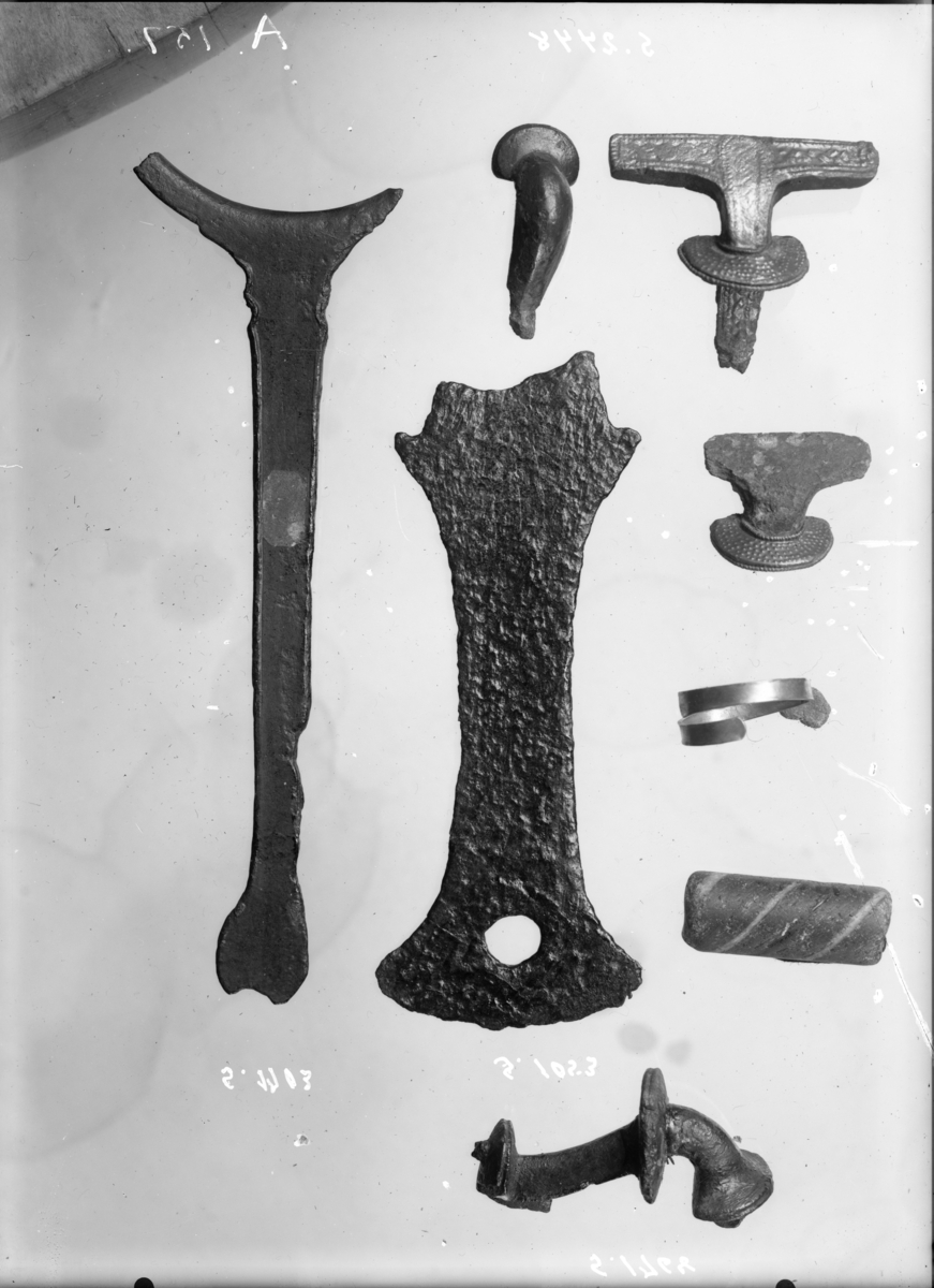 "1768. Spænde af bronce (pl. 2, fig. 10) fra ældre jernalder, 4,9 cm. lang." Ny beskrivelse etter revisjon:   
Fibula av bronse i to deler, stl: hhv. 31 og 24 mm. Tilhører Almgrens gruppe IV, kraftig profilert fibula, nærmest lik Almgren fig. 92. Spennen er knekt på bøylen rett foran kammen; nål, nålspiral og hylse mangler.Nålholderen er brukket på lengden. Bøylen har trekantet tverrsnitt, den skiveformede foten er dekorert med en liten knopp. Rød kobberkorrosjon på bruddflaten.