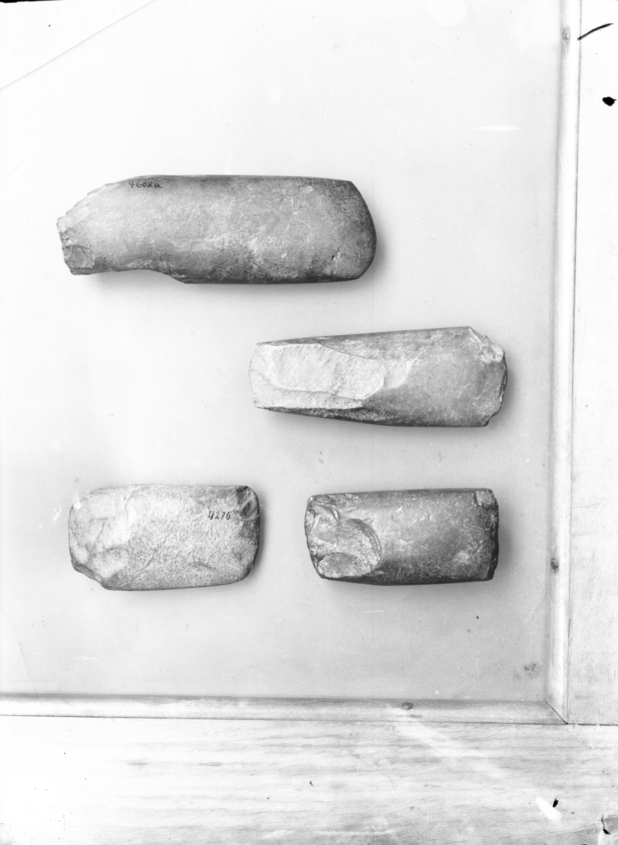 "4278 c. Trinnøks av vestlandstype av grøn bergart. Skiller sig fra den vanlige form derved at tversnittet er mere ovalt, og nakken forholdsvis bred. Slepen men med store arr bakover mot nakken. Eggen ødelagt i gammel tid, hvorefter øksen synes at ha været benyttet som slagsten. Længde 11,3 cm., største bredde nede ved eggen 4,4 cm. " Ny beskrivelse etter revisjon: 
Buttnakket trinnøks av grønngrå bergart med markert flatoval form. Eggen er skadet og har knusespor på undersiden etter sekundær bruk. Øksen er slipt, men nakkepartiet har til dels store arr etter tilhuggingen. Stl.: 113 mm, stb. ved egg: 44 mm, stt.: 30 mm.