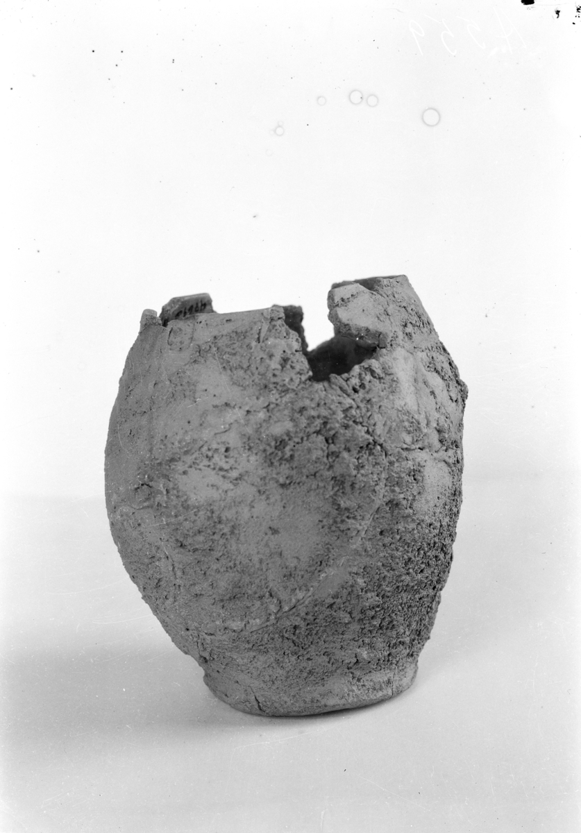 "4769 a. Lerkar nærmest som typen Sophus Müller: Ordning bronsealderen fig. 261 men uten den utbrettede kant oventil. Tverrmålet i munningen er 14 cm., over bukpartiet 19 cm., i bunnen 11,6 cm. (Avb. fig. 4)."
Enleddet leirkar med ruslemming på utsiden, fint glattet på innsiden, meget skakt og skjevt. På en side er karprofilen nesten rettvegget konveks med antydning til knekk på skulderen som er største diameter, på motsatt side ligger største diameter mye lavere,  karet er her mer buket med antydning til fot. Randpartiet  heller innover, og øverst har karet et glatt, ikke ruslemmet parti. Randen er rett avskåret. St.h: 214 mm, buk diam: 190 mm. 
/Ytterligere tre skår og fem smuler av leirkaret ble funnet ved gjennomgangen av de brente beina./