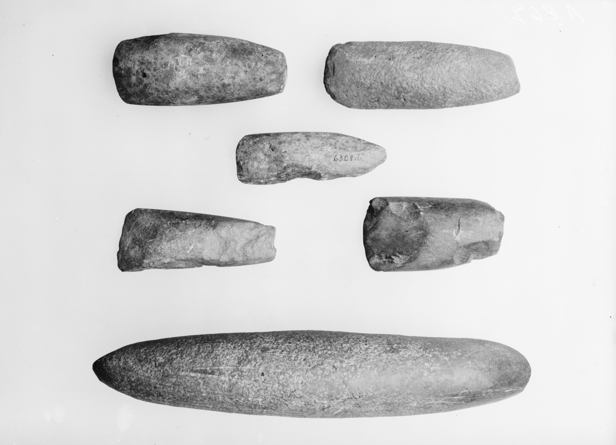 Buttnakket stenøks, sl. Gjessing l. c. fig. 73, tverregget ved tilslipning på den ene side, men tilslipningen begynner ovenfor midten. Lengde 11,6 cm., bredde 4,1 cm. 