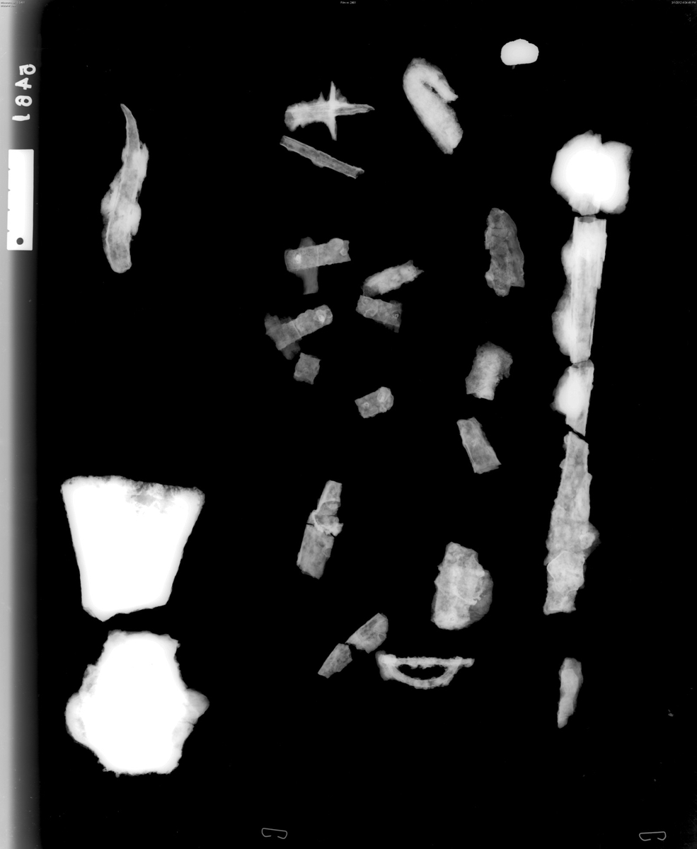 "Stkr. av økseblad av j., nu ganske deformert. Det har vel vært nærmest av typen R. 552, lengde 16 cm., bredde over eggen 8 cm., på det smaleste 3,8 cm."  Ny beskrivelse etter revisjon: To fragmenter av økseblad av jern, halsen mangler; bladfragment, stl.: 72 mm, egg br.: 72 mm og nakke/skafthullfragment, stl.: 71 mm, nakke h.: 40 mm, nakke br.: 48 mm (inkl. korrosjon), hals h.: 36 mm,  hals br.: 27 mm. 