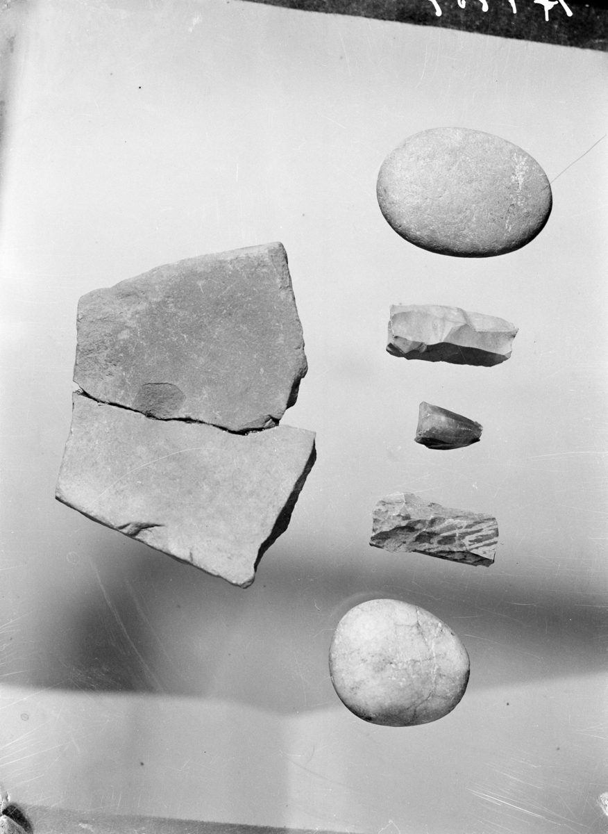 "e. 25 flekkeblokker av flint og årekvarts. Fig. 7" Ny beskrivelse etter revisjon: Tredve kjerner, derav tjueni kjerner av flint og en kjerne av rhyolitt. Ti ensidige kjerner med motstående plattformer, en flersidig kjerne med motstående plattformer, fire bipolar kjerner, en konisk mikroflekkeblokk, ti uregelmessige kjerner og to sylindriske kjerner.