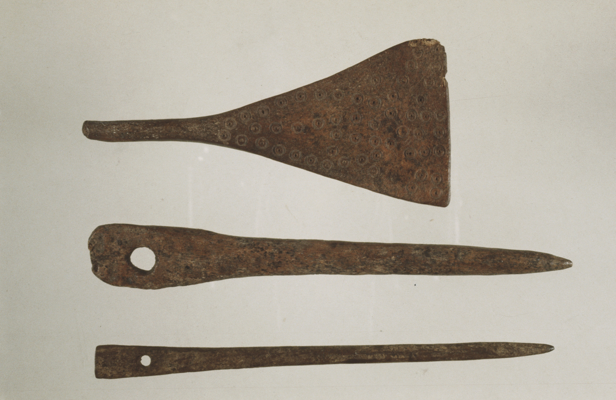 "Nål av bein med flatt hovud, nærast som Blomqvist og Mårtensson 1963 fig 182 c men utan typeeks. markerte overgang frå kropp til hovud. 12.2 cm lang, inntil 1.6 cm brei over hovudet (728)." I samsvar med beskrivelsen, avb. SMÅ 1968, fig. 9c (nr. 3 fra øverst).
