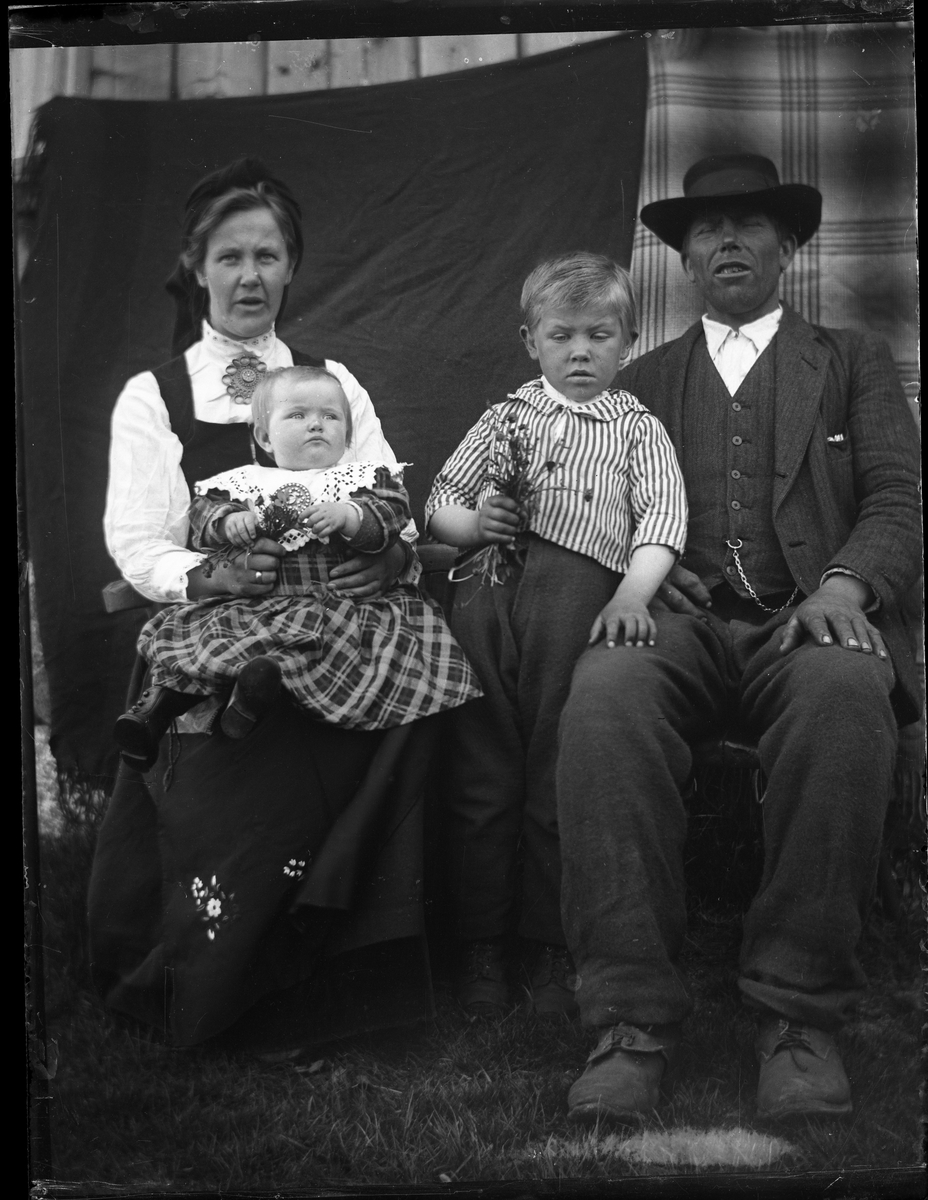 Portrett av Olav Gunleikson Ø. Øysæ (1873-1967) og Signe Gunnarsdotter (1893-1983), med barna Gunleik (1913-) og Anne (1917-1983), fotografert i utendørs atelier.

Fotosamlingen etter Olav Tarjeison Midtgarden Metveit (1889-1974), Fyresdal. Senere (1936) kalte han seg Olav Geitestad.