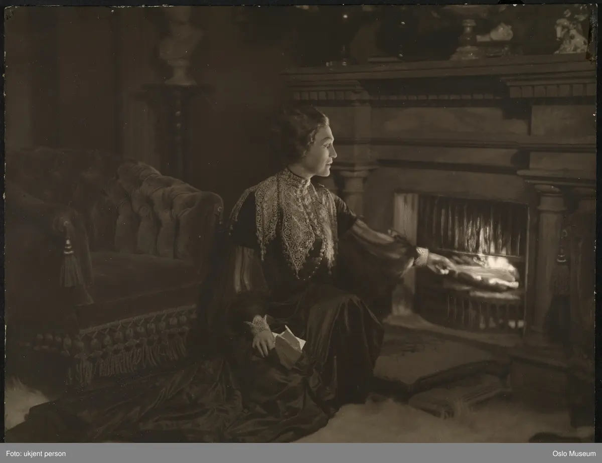 scenebilde, tittelrollen i "Hedda Gabler" på Nationaltheatret, knelende helfigur ved peis, Hedda brenner Ejlert Løvborgs manuskipt