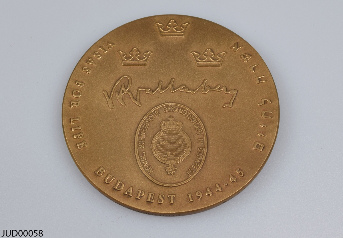 Två stycken bronsmedaljer liggandes i varsin plastask med tillhörande certifikat. Dekorerade med ett porträtt av Raoul Wallenberg samt dennes signatur. Även dekorerade med texten "Raoul Wallenberg - Sweden. Visas for Life. Budapest 1944-1945" samt med hebreisk text (Raoul Wallenberg på hebreiska).
