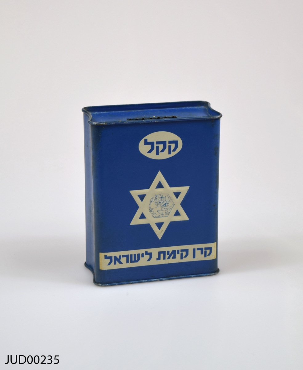 Insamlingsbössa, tillverkad av plåt och sedan målad med mörkblå färg. Dekorerad med vit davidsstjärna samt vit hebreisk text.