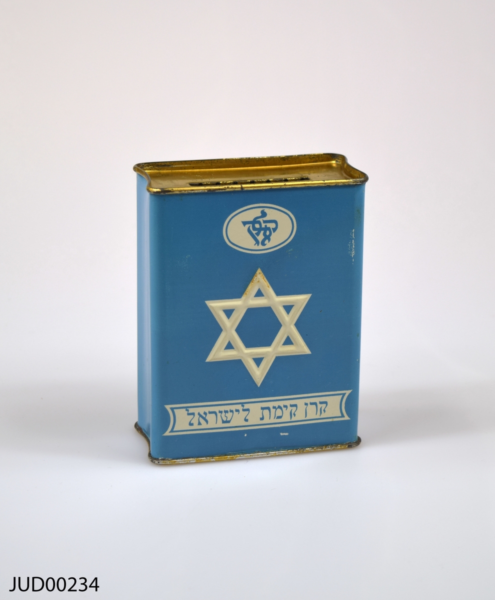 Insamlingsbössa, tillverkad av plåt och målad med turkos färg. Dekorerad med vit davidsstjärna samt vit hebreisk text.