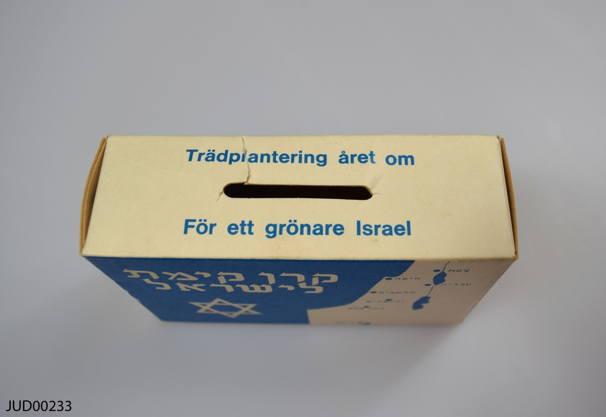 Insamlingsbössa, tillverkad av papper. Dekorerad med Israels flagga samt en karta över landet. Följande text står på bössan:

"Trädplantering året om. För ett grönare Israel"

"Keren Kajemet - Judiska Nationalfronden i Sverige. Nybrogatan 19, 114 39 Stockholm. Telefon 08-618686, postgiro 150376-2"

"Skogsplatering och dränering är ett livsvillkor för en framgångsrik utveckling av Israel"

"Keren Kajemet har till uppgift att i Israel förbättra marken och göra den lämplig för kolonisation samt att täcka bergskullar och ökentrakter med träd"