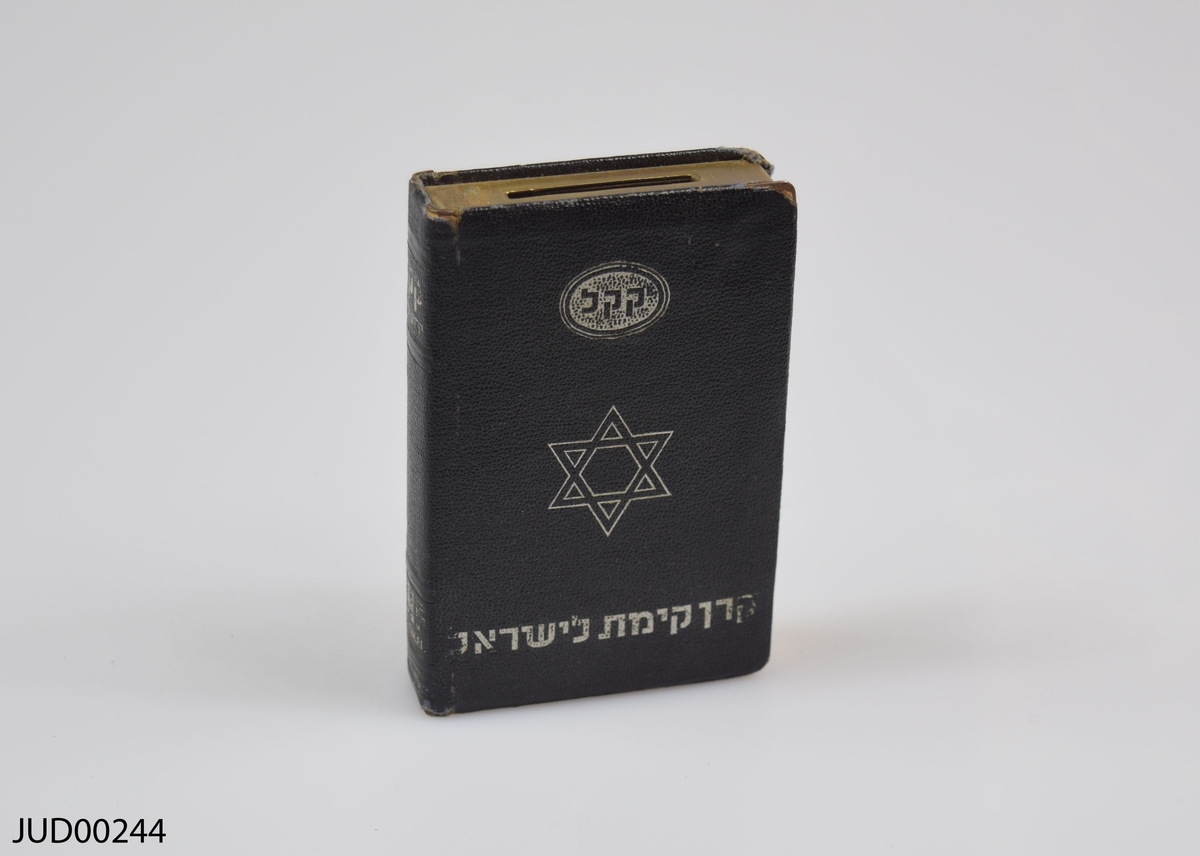 Två stycken insamlingsbössor utformade som böcker, tillverkade av mässing. Silvrig dekor i form av Davidsstjärna, karta över Israel samt hebreisk text. Även dekorerad med följande text:
Keren Kayemeth Leisrael
JNF Jerusalem