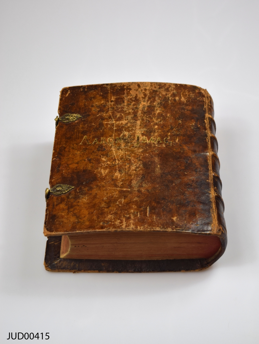 Stor chumash med kommentarer på hebreiska, som har tillhört Aaron Isaac. Läderband, med förgyllt stämpeltryck som säger "Aaron Isaac". Spännen tillverkade av läder, med beslag tillverkade av metall. Textilskodda kapitälband. Rödfärgade snitt.