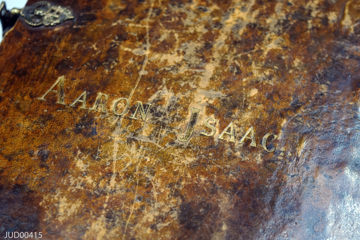 Stor chumash med kommentarer på hebreiska, som har tillhört Aaron Isaac. Läderband, med förgyllt stämpeltryck som säger "Aaron Isaac". Spännen tillverkade av läder, med beslag tillverkade av metall. Textilskodda kapitälband. Rödfärgade snitt.