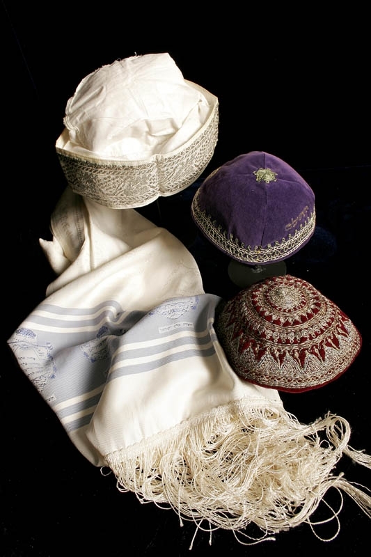 Kippa tillverkad av lila sammet. Kippan är dekorerad med kedjesöm runt kanten och olika silvertrådsbroderade rundlar. På toppen finns en liten fastsydd snurrad tråd. Ordet "Jerusalem" på hebreiska inbroderat på kippan.