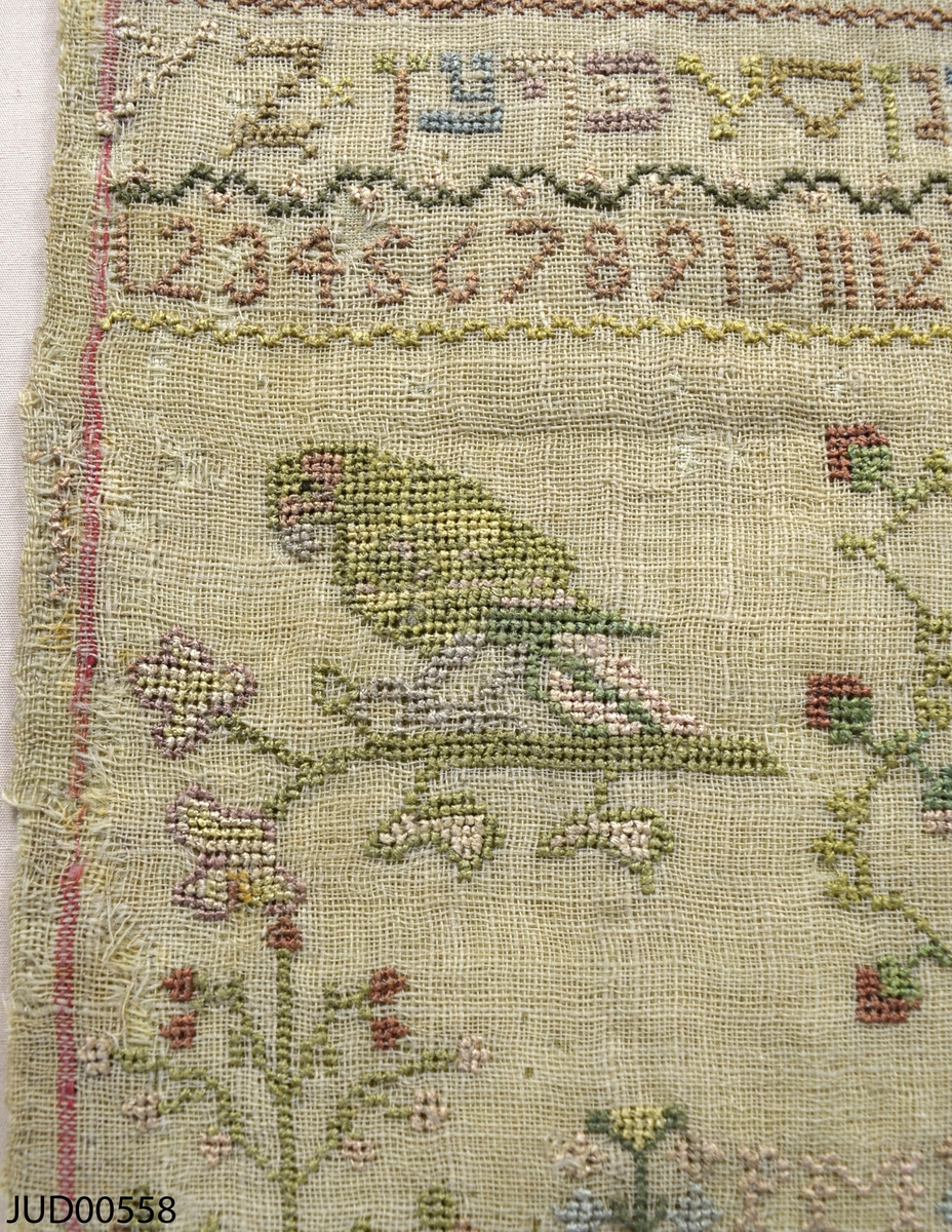 Märkduk med broderier. En blandning av broderade latinska och hebreiska bokstäver, siffror och  figurer.