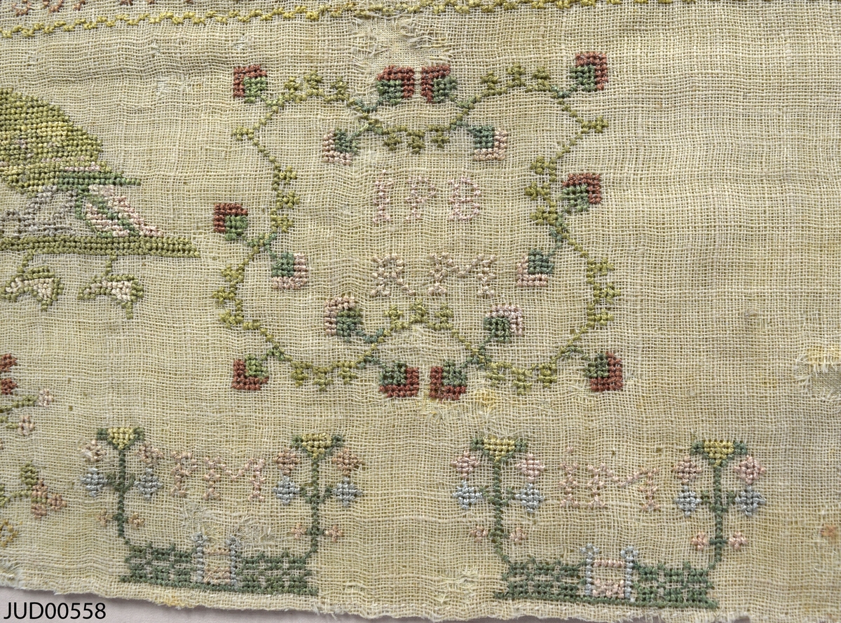 Märkduk med broderier. En blandning av broderade latinska och hebreiska bokstäver, siffror och  figurer.