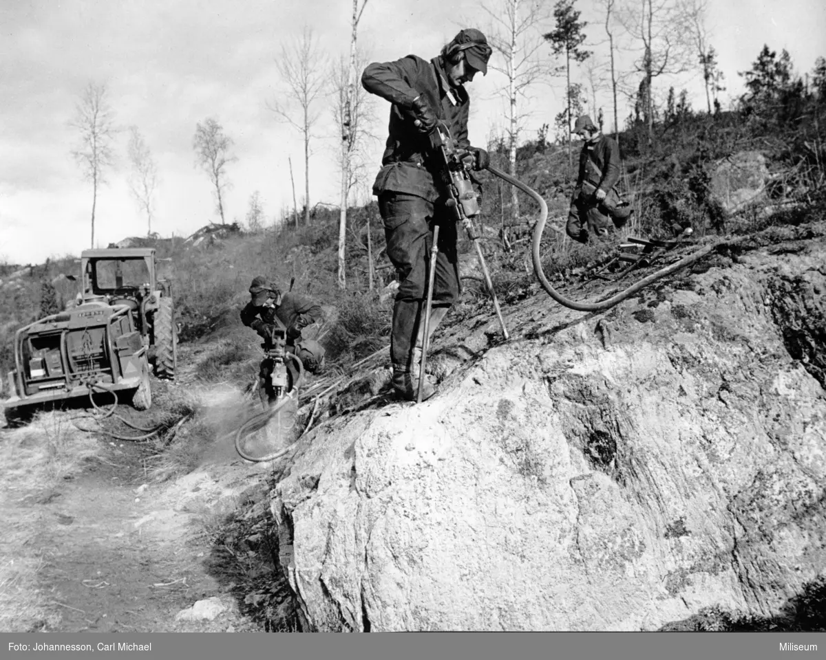 Borrning inför spängning. Värnpliktig furir Ryner. Tryckluftkärra till vänster.