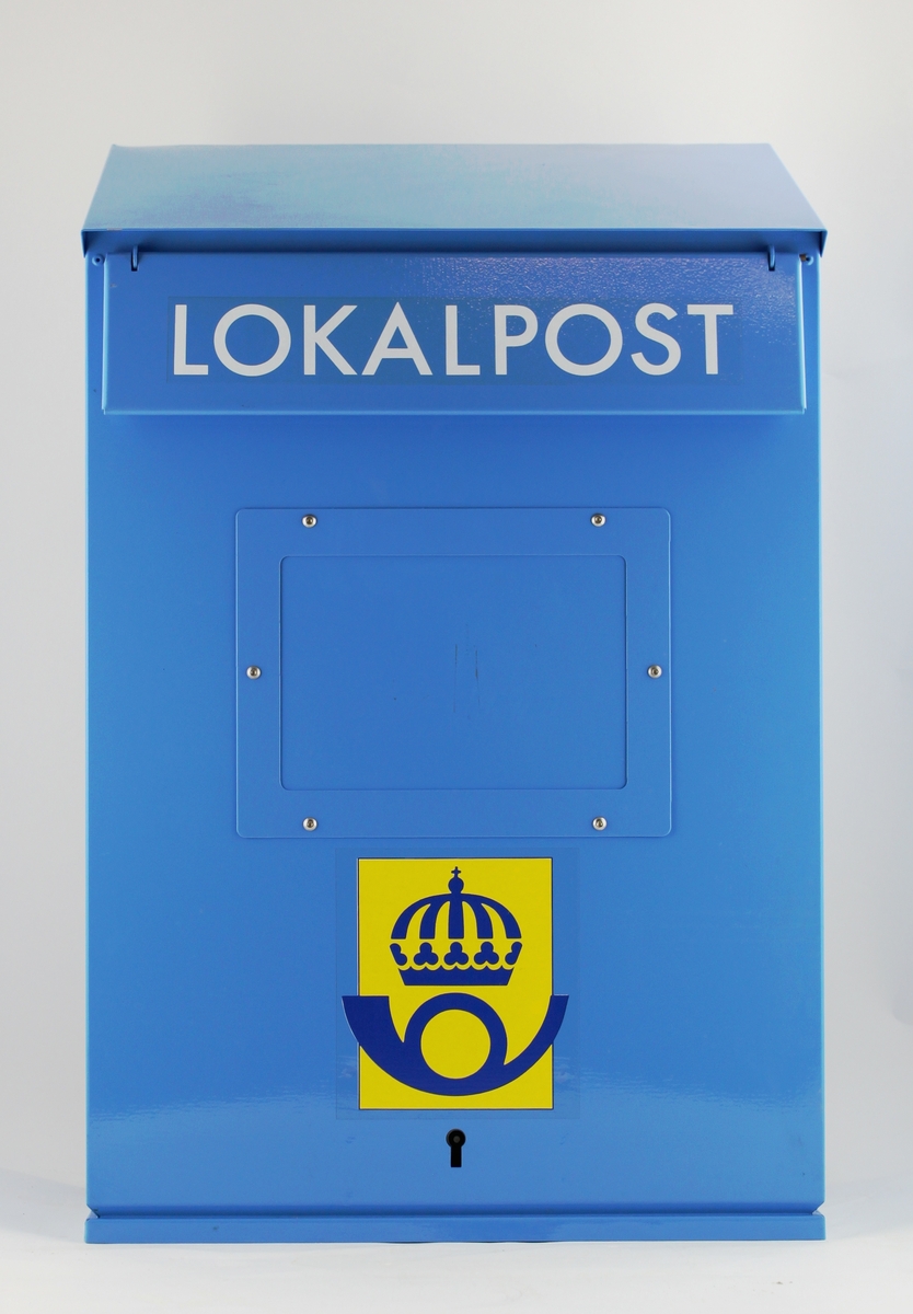 Blå lokalpostbrevlåda med 1985 års postsymbol. Text i vita versaler: Lokalbrev. Försedd med anslagsfönster för tömningstider. Bottentömning och tömningsluckan är försedd med falsband.