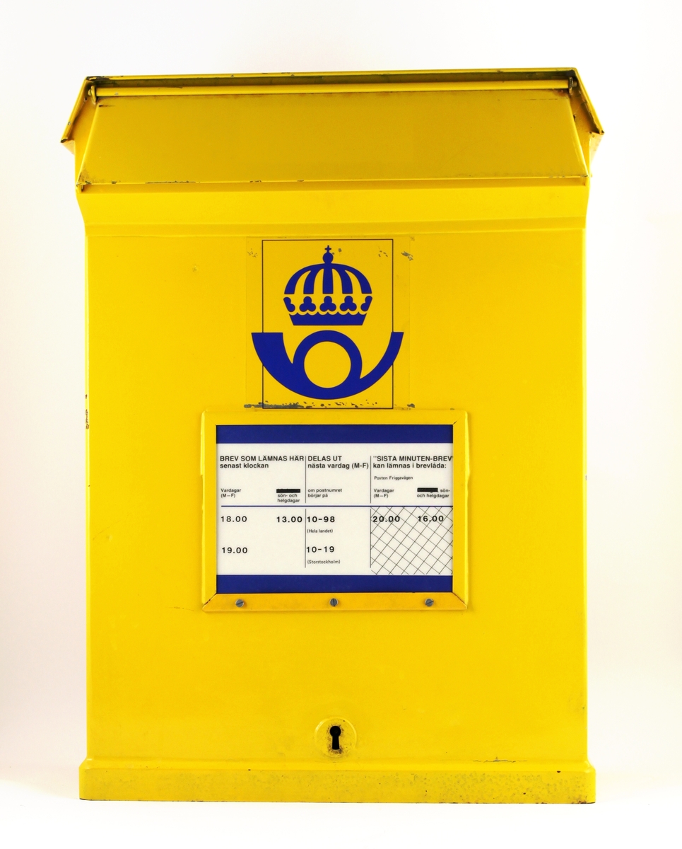 Brevlåda med bottentömning. Brevlådan är tillverkad med en utskjutande överdel och ett större brevinkast än de tidigare modellerna. På fronten ett anslagsfönster och en postsymbol av 1984
års modell.