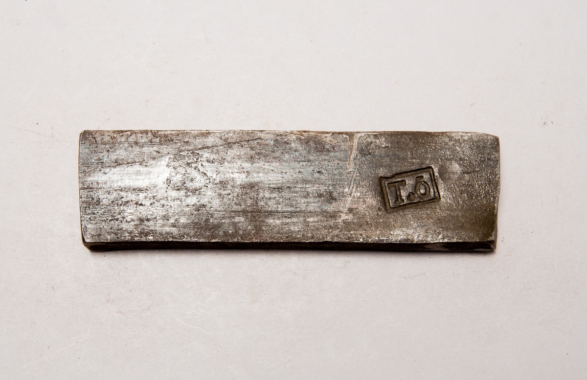 Järnstämpel från Elfkarleö. Stämpeln är ett stort "T" med ett stort "Ö" med "+" mellan dom. Har numret 514 instansat på ena kortsidan.